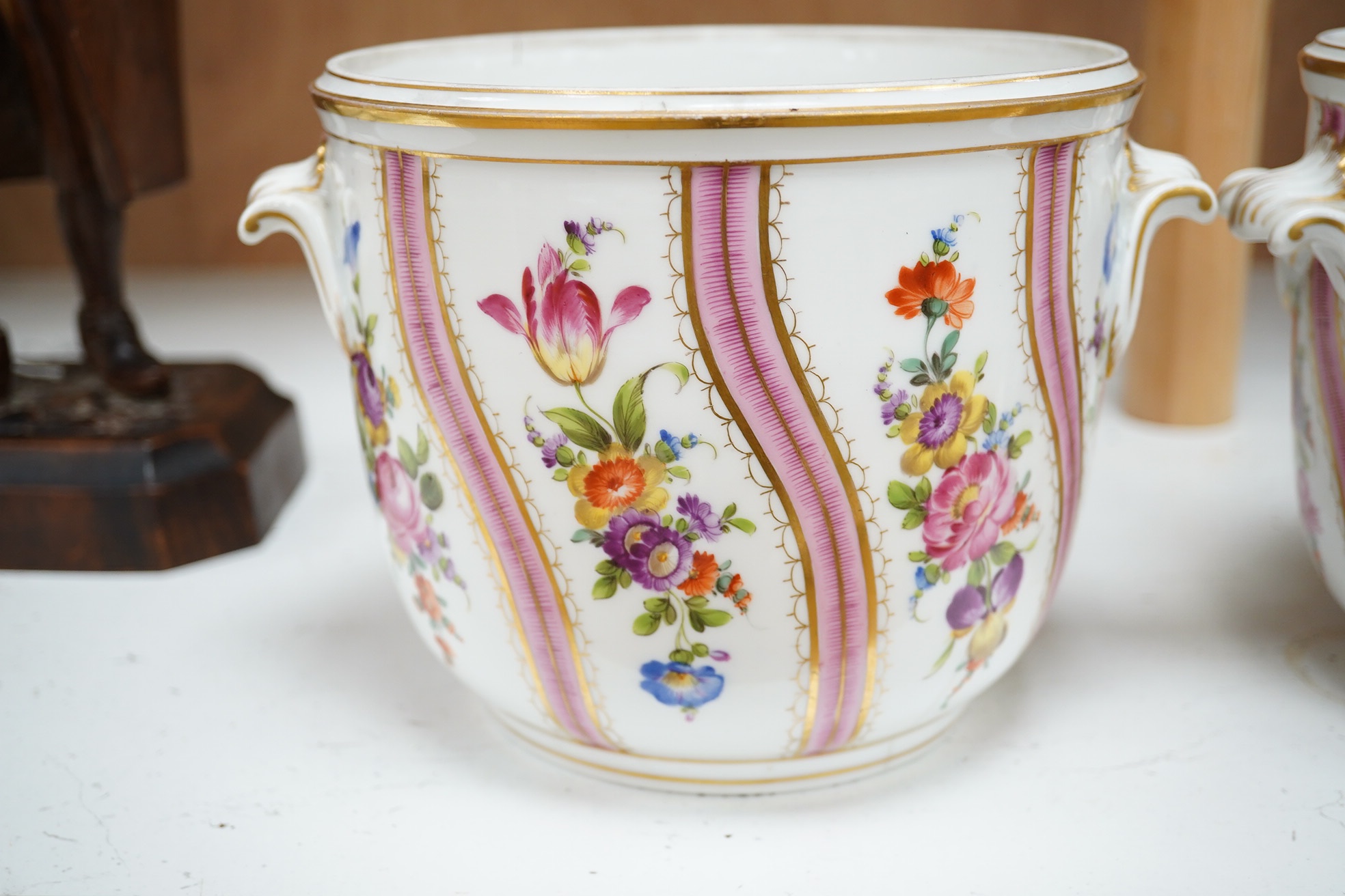 A pair of Dresden wine coolers with floral decoration, 15cm high, 18cm diameter. Condition poor to fair, cracks to the base of one.